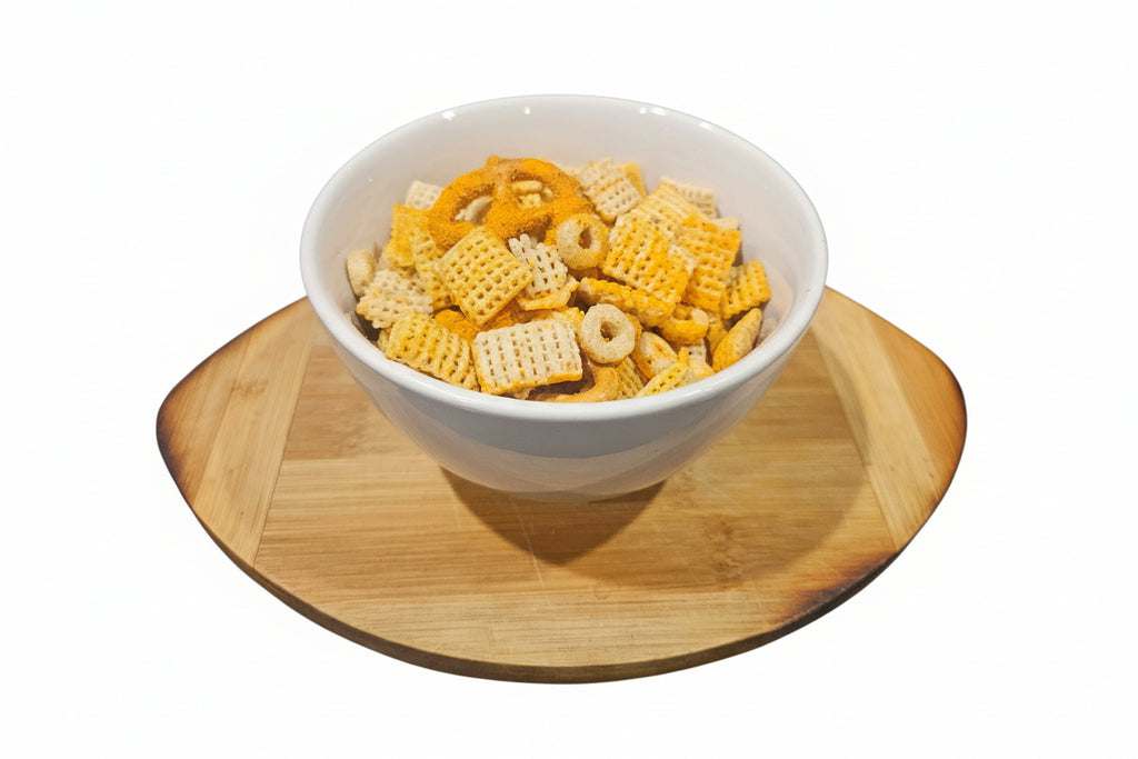 Bowl of snack mix on a wooden coaster with a white background