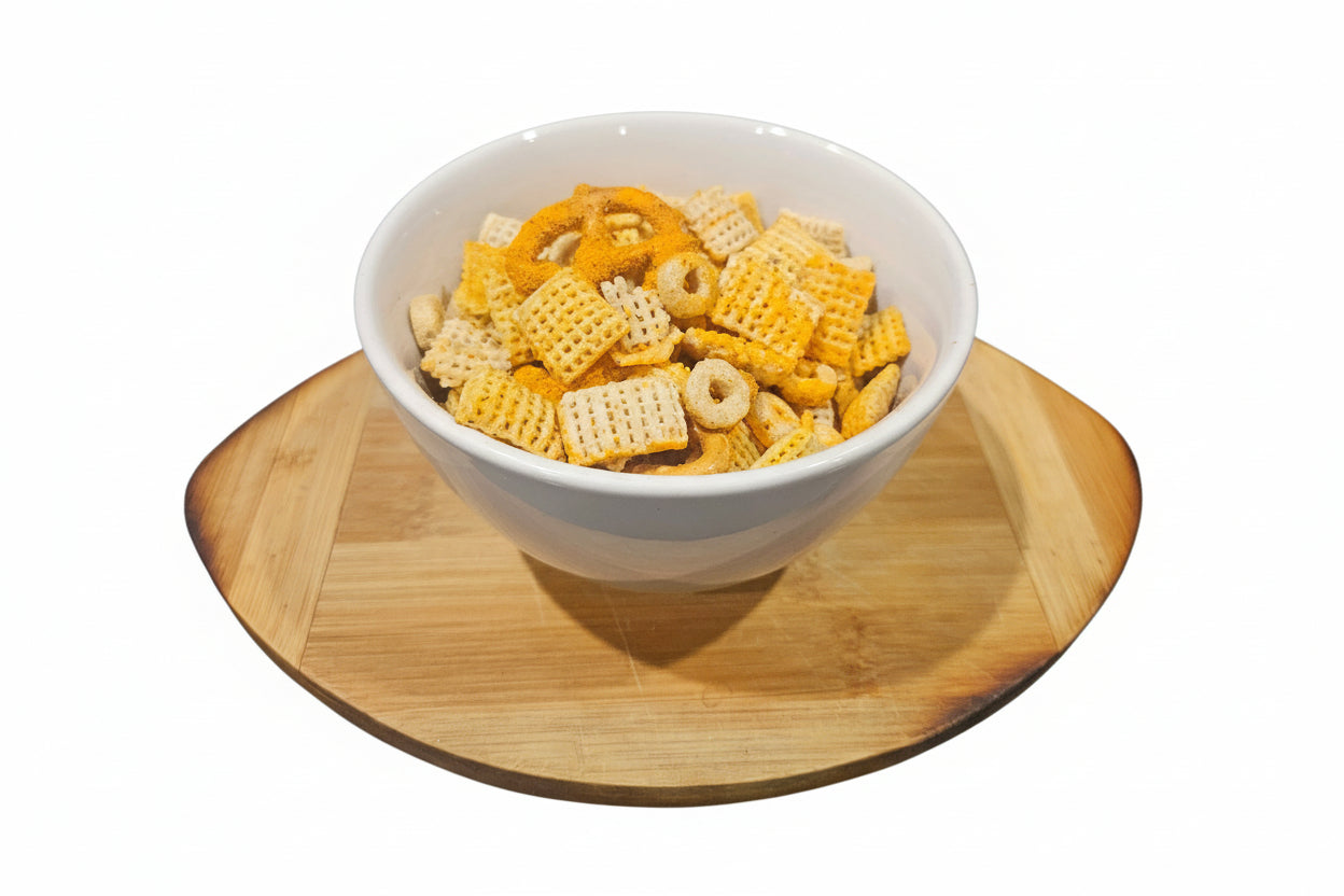 Bowl of snack mix on a wooden coaster with a white background