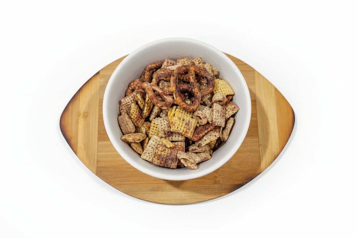 White bowl with Chocolate covered cherries snack mix on a wooden coaster