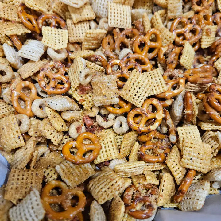 Assorted snack mix with pretzels and cereal pieces on a plate