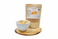 Bag of salted caramel snack mix next to a bowl of snack mix on a white background