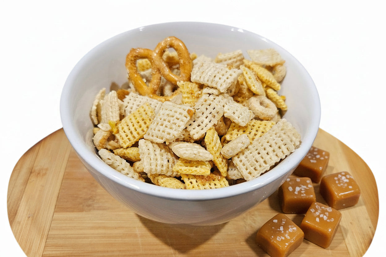 White bowl filled with a snack mix on a wooden cutting board