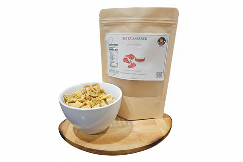 Bag of Buffalo Ranch flavored snack mix next to a bowl of snacks on a wooden board with a white background