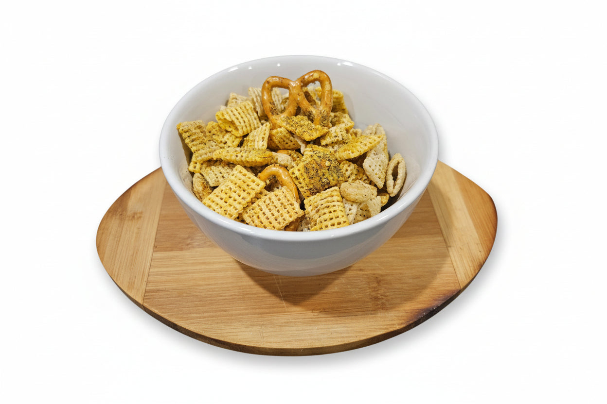 White bowl with buffalo ranch snack mix on a wooden coaster