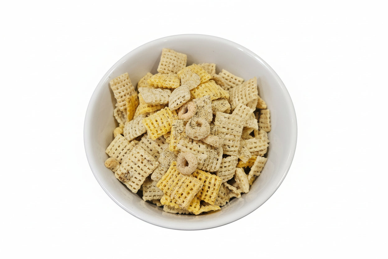 White bowl filled with dill pickle gourmet snack mix on a wooden cutting board
