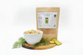 Bowl of dill pickle snacks on a wooden cutting board with a package labeled 'Dill Pickle' in the background.