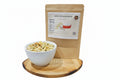 White bowl with gourmet snack mix on a wooden cutting board next to a bag of White Cheddar Ranch seasoning.