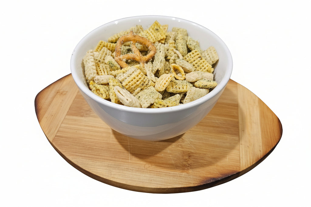 White bowl filled with snack mix on a wooden cutting board