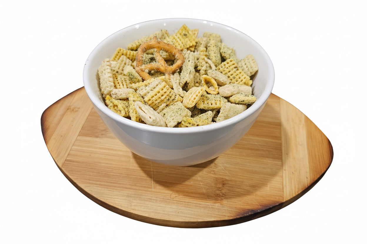 White bowl filled with snack mix on a wooden cutting board
